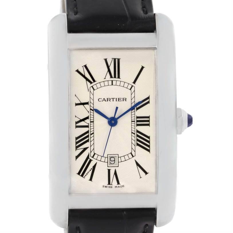 The image shows a frontal view of the Cartier Tank Américaine watch, highlighting its face, Roman numerals, date window, and leather strap.