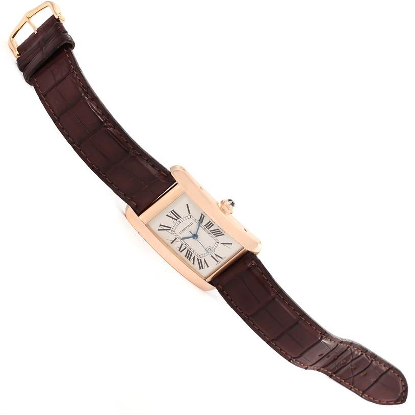 The image shows a Tank Américaine model by Cartier from a top-down angle, highlighting the timepiece and its leather strap.