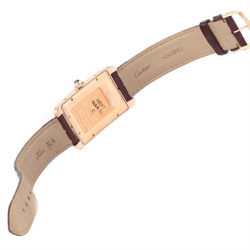 The image shows the back and strap of a Cartier Tank Americaine W2609156 Rose Gold Silver Dial W2609156 Rose Gold Silver Dial watch, displaying the case back details and leather band
s interior.