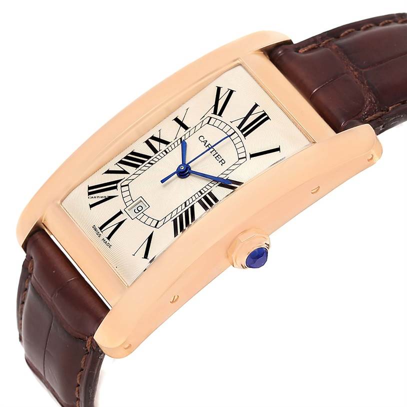 This image shows a side angle of a Cartier Tank Americaine W2609156 Rose Gold Silver Dial W2609156 Rose Gold Silver Dial watch, highlighting the dial, strap, and crown with a blue gem.