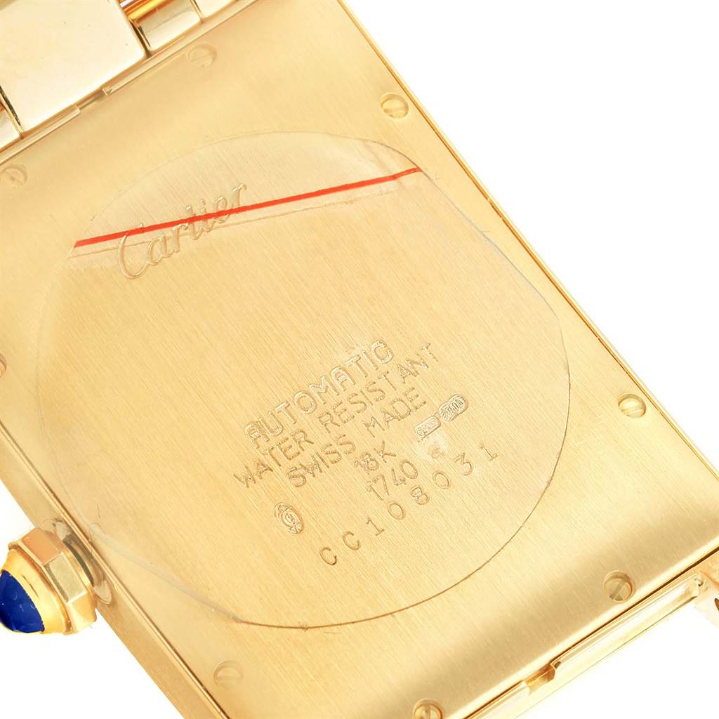 The image shows the back side of the Cartier Tank Americaine W26031K2 Men
s Yellow Gold Silver Dial W26031K2 Men
s Yellow Gold Silver Dial watch, highlighting its water resistance, automatic movement, and 18K gold casing.