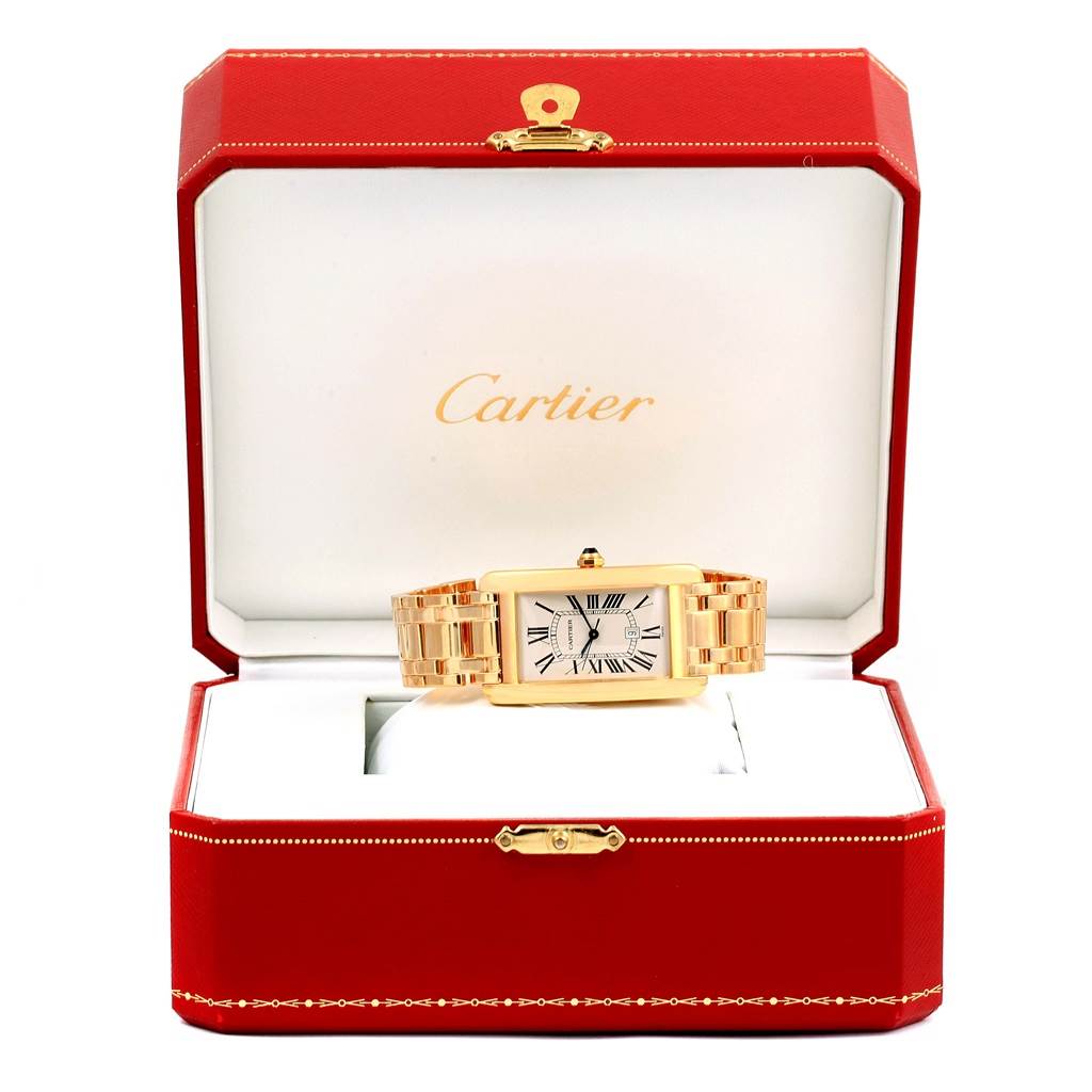 The image shows a Cartier Tank Americaine W26031K2 Men
s Yellow Gold Silver Dial W26031K2 Men
s Yellow Gold Silver Dial watch, angled from the front, inside its branded red box.