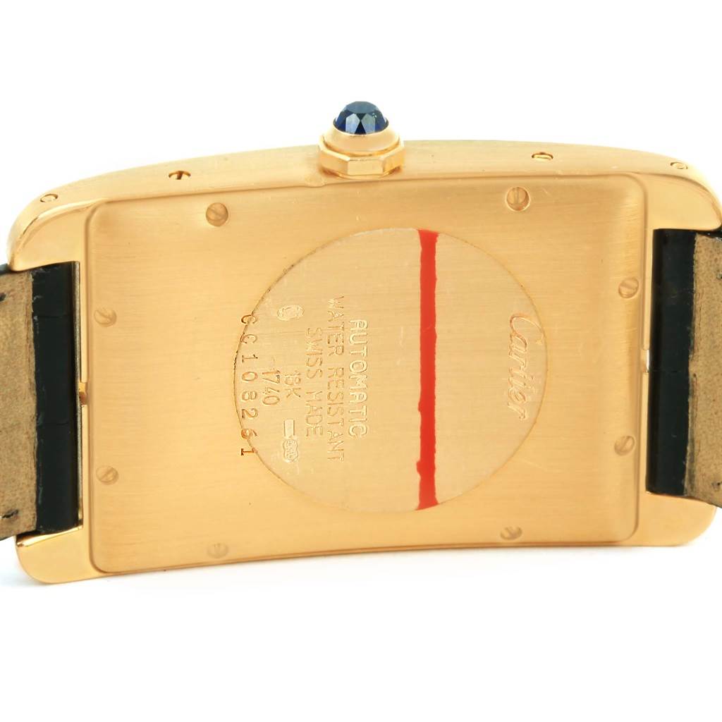 The image shows the back view of a Cartier Tank Américaine watch, highlighting the engraving details and the cabochon crown.