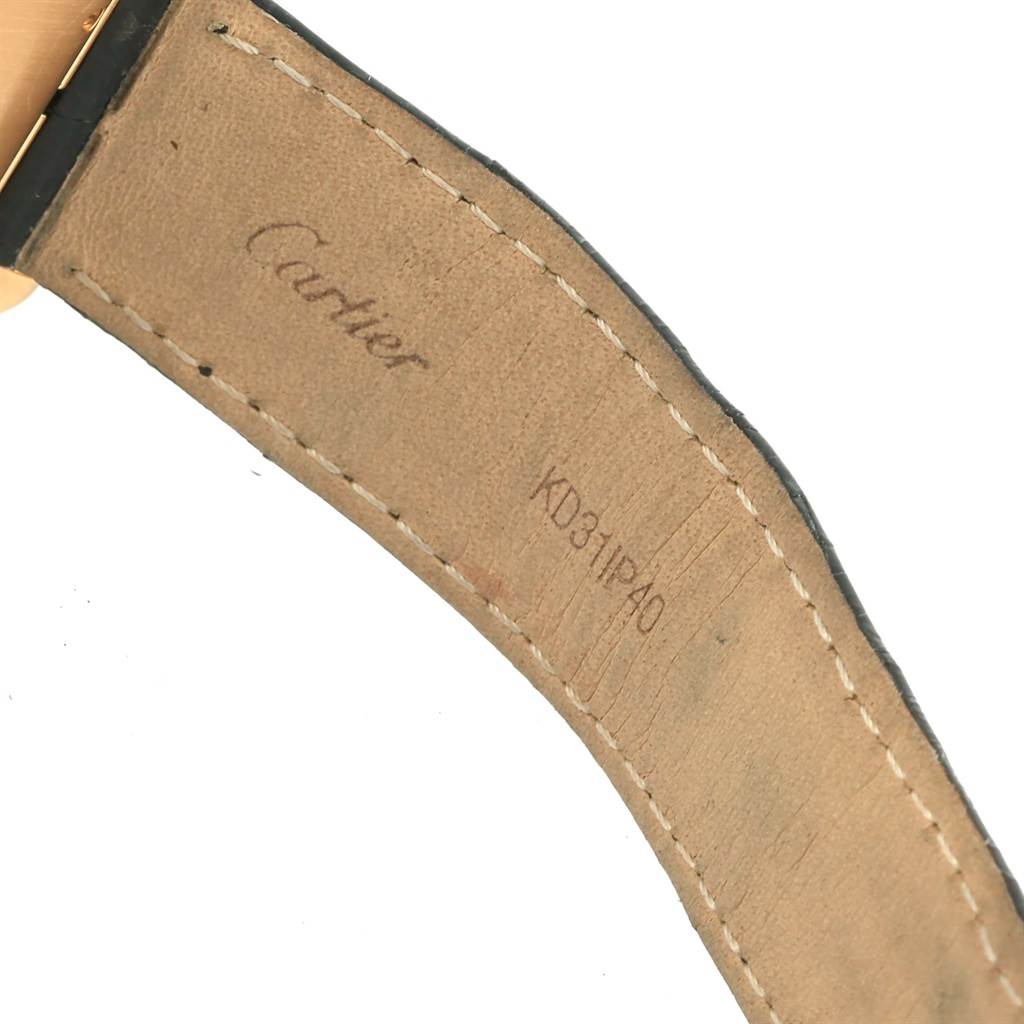 The image shows the interior side of the leather strap for a Cartier Tank Américaine watch, featuring branding and a serial number.
