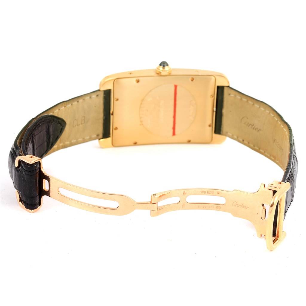 The image shows the back and clasp of a Cartier Tank Americaine W2603156 Men's Yellow Gold Silver Dial W2603156 Men's Yellow Gold Silver Dial watch, highlighting the leather strap and gold deployant buckle.