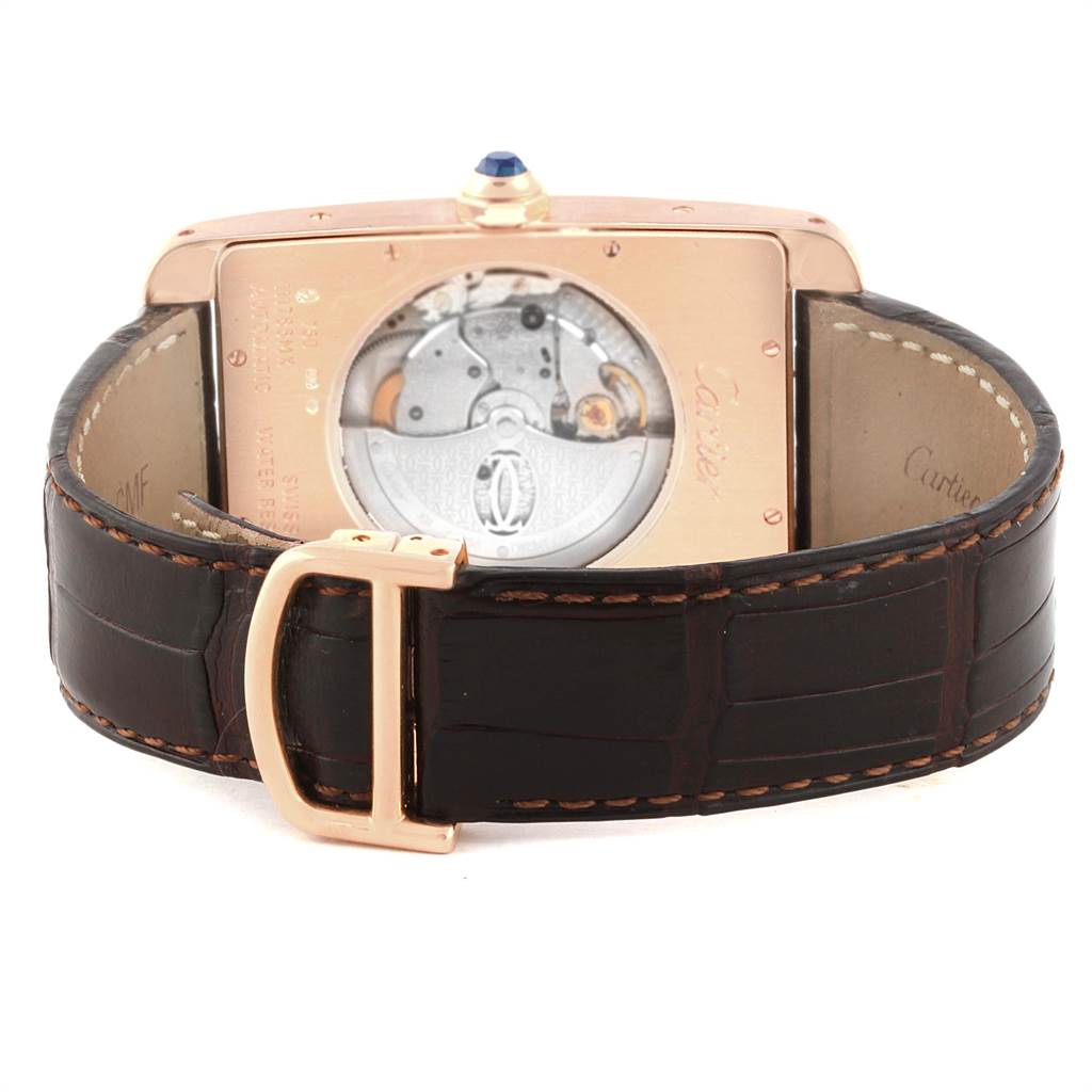 The image shows the back view of a Cartier Tank Americaine W2609856 Men's Rose Gold Silver Dial W2609856 Men's Rose Gold Silver Dial watch, highlighting its movement and the leather strap with a buckle.