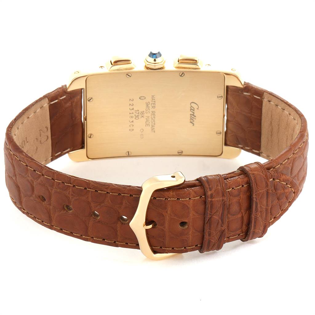 This image shows the back of the Cartier Tank Americaine W2601156 Men's Yellow Gold Silver Dial W2601156 Men's Yellow Gold Silver Dial watch and its brown leather strap with a gold buckle.