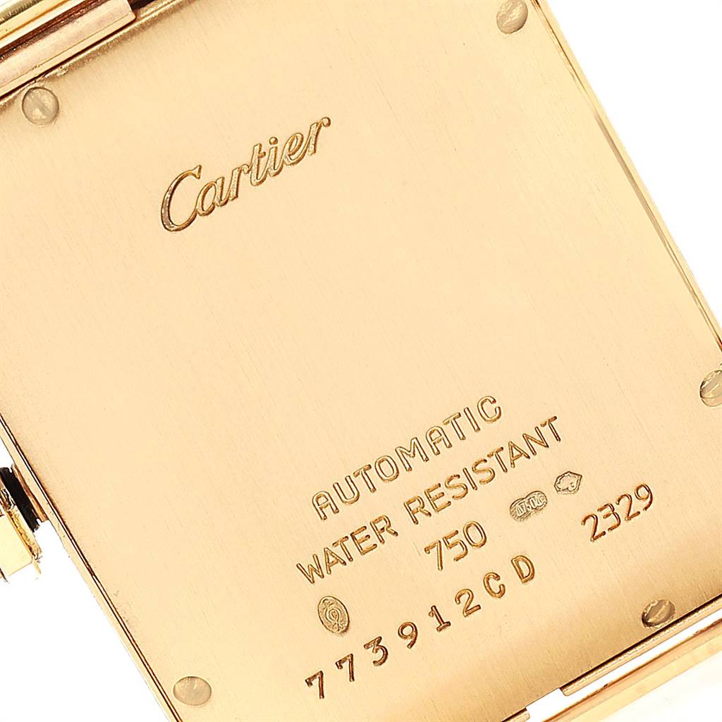 The image shows the back case of a Cartier Tank Americaine W2603156 Men's Yellow Gold Silver Dial W2603156 Men's Yellow Gold Silver Dial watch, highlighting its inscriptions and serial numbers.