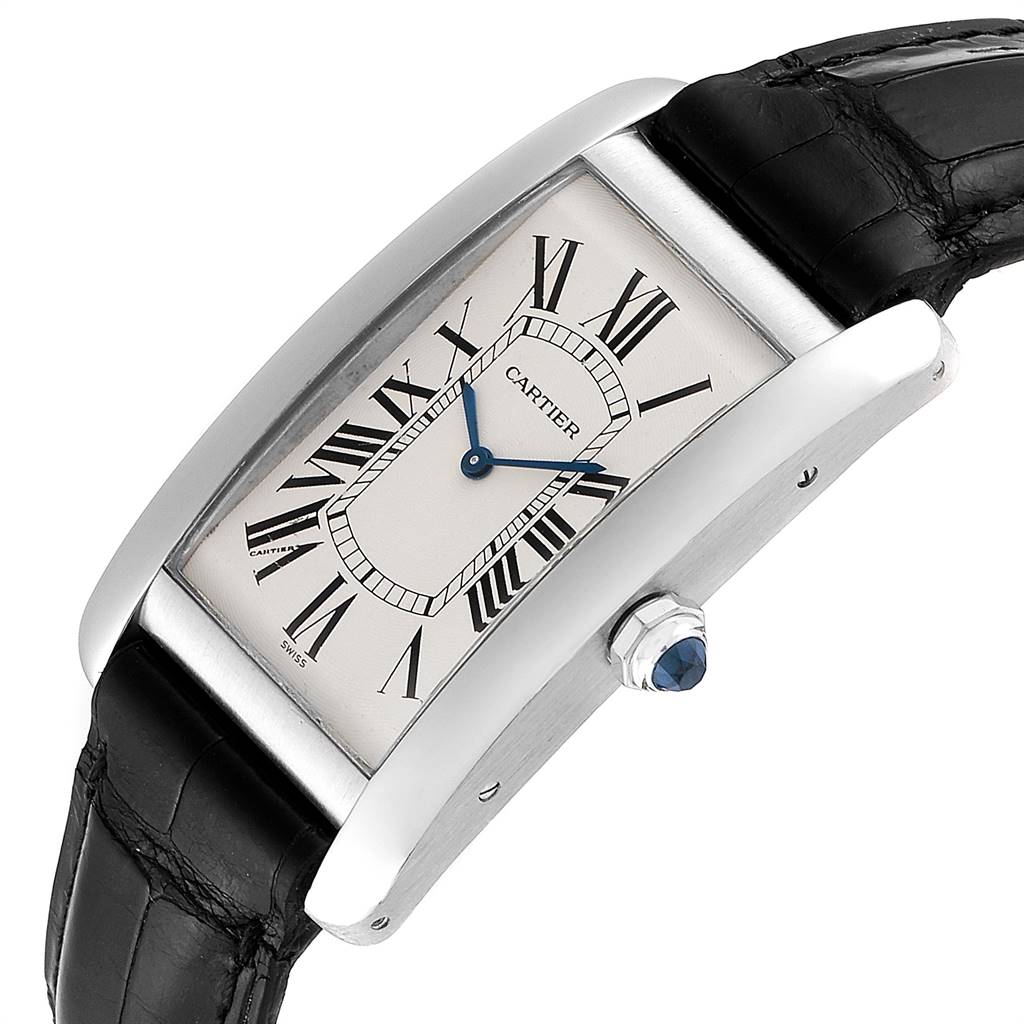 This image shows the Cartier Tank Americaine W2604351 Men's Platinum Silver Dial W2604351 Men's Platinum Silver Dial watch from an angled view, highlighting its face, blue hands, Roman numerals, and black strap.