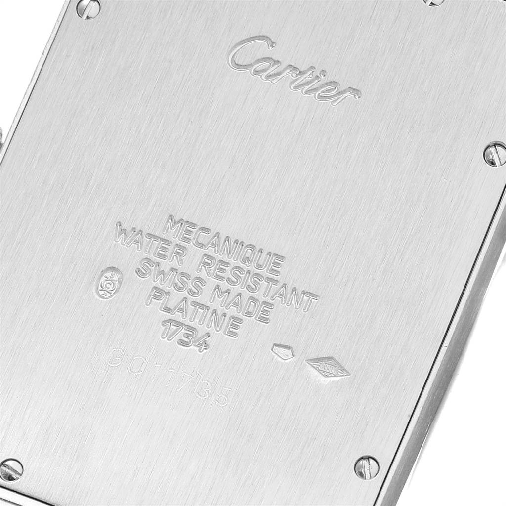 This image shows the engraved back case of a Cartier Tank Americaine W2604351 Men's Platinum Silver Dial W2604351 Men's Platinum Silver Dial watch, highlighting inscriptions and screws.
