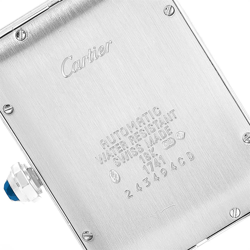 The image shows the back casing and crown of a Cartier Tank Americaine W2605229 Men
s White Gold Grey Dial W2605229 Men
s White Gold Grey Dial watch at an angled close-up view.