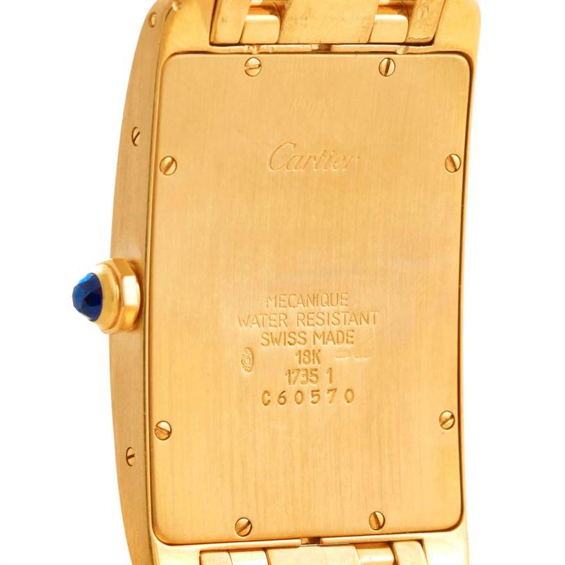 The image shows the back of a Tank Americaine model by Cartier, highlighting its engraved details and crown with a blue stone.