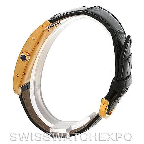 The image shows a Cartier Tank Américaine watch from a side angle, highlighting the gold case, black leather strap, and crown.