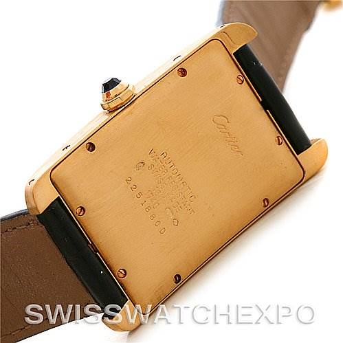 The image shows the back case of a Cartier Tank Américaine watch, revealing its serial number and inscriptions.