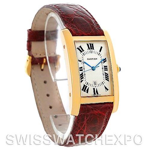 The image shows a Cartier Tank Américaine watch angled slightly to display its face, gold case, and brown leather strap.