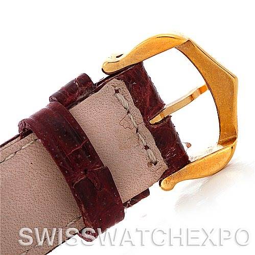 This image shows a close-up of the buckle and leather strap from a Cartier Tank Americaine W2603556 Men's Yellow Gold Silver Dial W2603556 Men's Yellow Gold Silver Dial watch, highlighting the gold buckle and stitching on the strap.