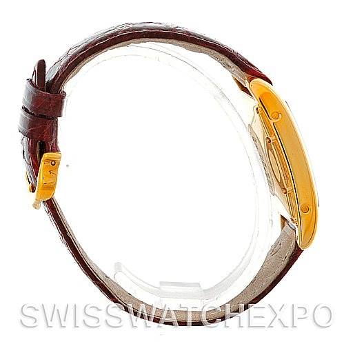 The image shows a side view of the Cartier Tank Americaine W2603556 Men's Yellow Gold Silver Dial W2603556 Men's Yellow Gold Silver Dial watch, displaying the gold case and brown leather strap with buckle.