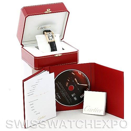 The image shows a Cartier Tank Americaine W2603156 Men's Yellow Gold Silver Dial W2603156 Men's Yellow Gold Silver Dial watch with its open box, certificate of authenticity, and accompanying CD.