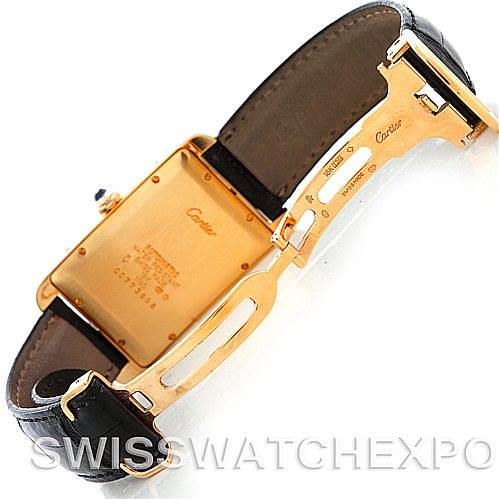 This is a rear view of a Tank Americaine model by Cartier showing the gold case back and part of the open leather strap.