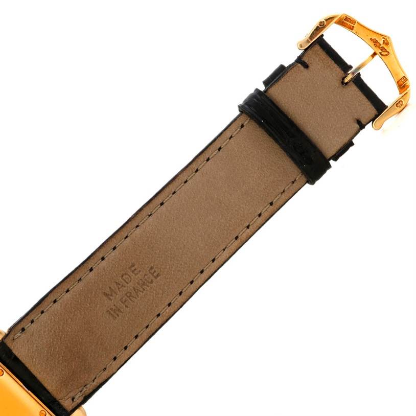 The image shows the underside of the strap and the gold buckle of a Tank Americaine model by Cartier.