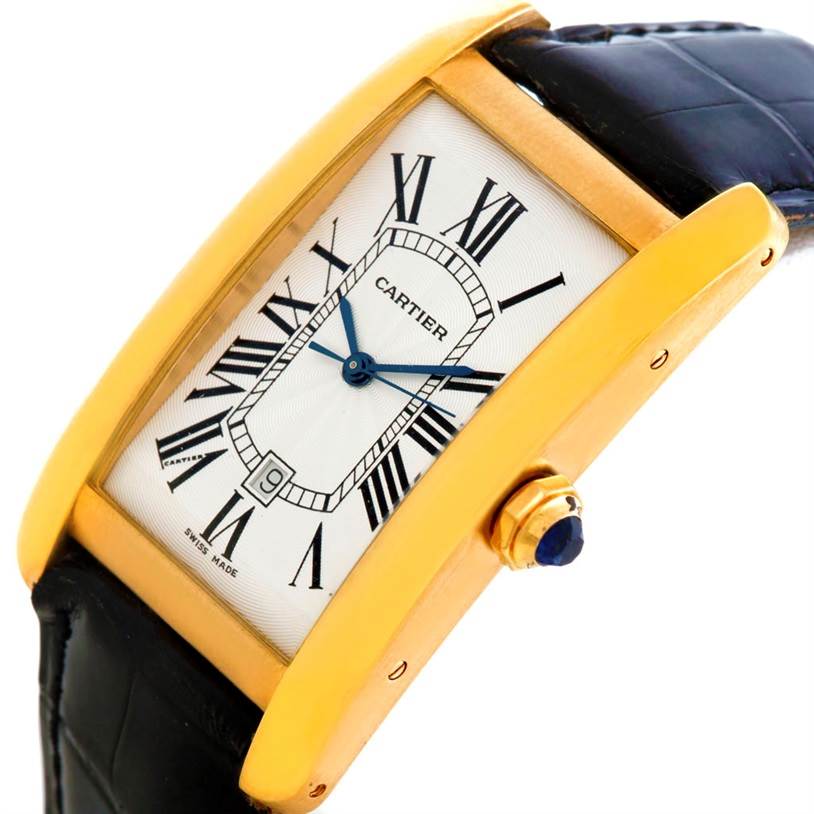 This image shows a Cartier Tank Americaine W2603156 Men's Yellow Gold Silver Dial W2603156 Men's Yellow Gold Silver Dial watch at a slight angle, highlighting its gold case, blue hands, and black leather strap.