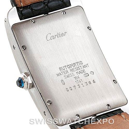 This image shows the caseback and part of the strap of a Cartier Tank Americaine W2603256 Men's White Gold Silver Dial W2603256 Men's White Gold Silver Dial watch, including engravings and a blue cabochon crown.