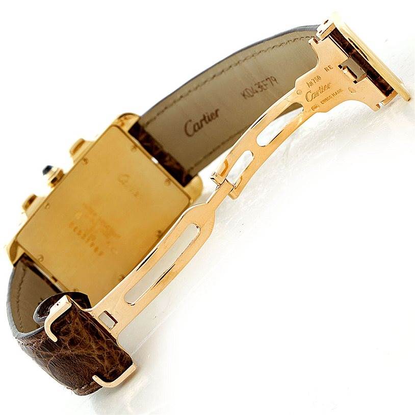 The image shows the back and clasp of the Cartier Tank Americaine W2605856 Men's Yellow Gold Silver Dial W2605856 Men's Yellow Gold Silver Dial watch at an angle, highlighting the gold case and brown leather strap.