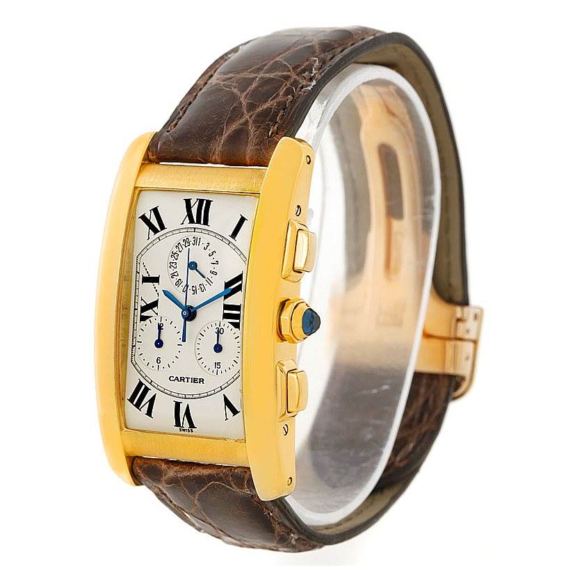 The Cartier Tank Americaine W2605856 Men's Yellow Gold Silver Dial W2605856 Men's Yellow Gold Silver Dial watch is shown at an angle highlighting its face, side buttons, and brown leather strap.