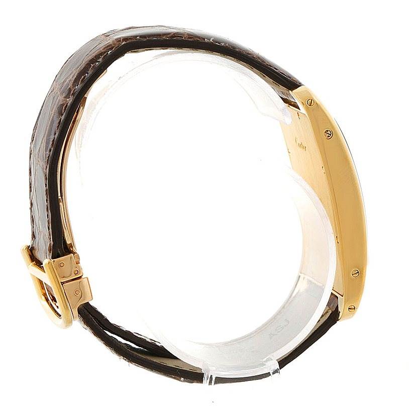 The image shows a side view of a Cartier Tank Americaine W2605856 Men's Yellow Gold Silver Dial W2605856 Men's Yellow Gold Silver Dial watch, highlighting its case, screws, and leather strap with buckle.