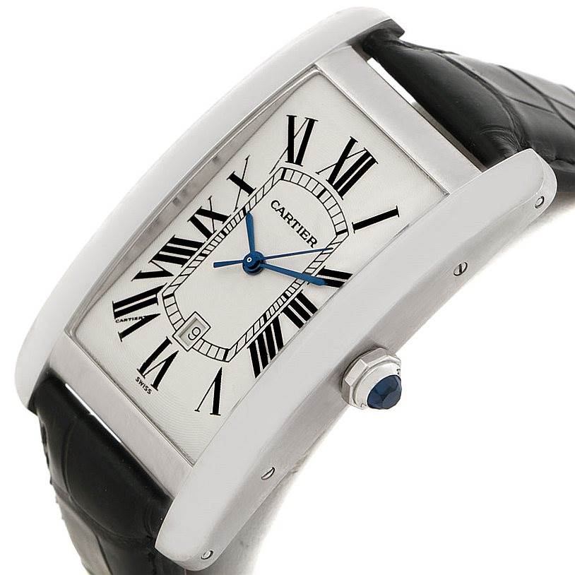 This image shows a Cartier Tank Americaine W2603256 Men
s White Gold Silver Dial W2603256 Men
s White Gold Silver Dial watch at an oblique angle, highlighting its face, crown, and part of the strap.