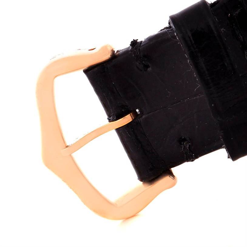 This image shows a close-up of the black leather strap and gold buckle of a Cartier Tank Américaine watch.