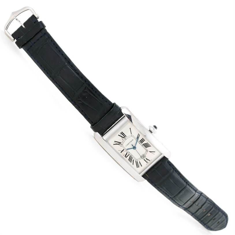 The Cartier Tank Americaine W2603256 Men's White Gold Silver Dial W2603256 Men's White Gold Silver Dial watch is shown at a three-quarter angle, displaying its rectangular face, Roman numeral dial, and black leather strap.