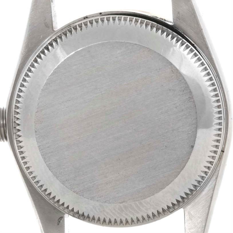 This image shows the case back of a Rolex Oyster Perpetual 76183 Women's Steel and Gold (two tone) Grey Dial 76183 Women's Steel and Gold (two tone) Grey Dial watch from a top-down angle.