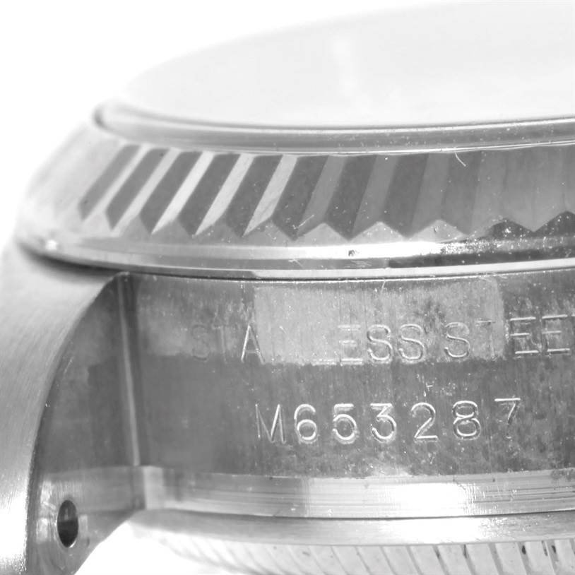 This close-up image of a Rolex Oyster Perpetual 176234 Women's Stainless Steel White Dial 176234 Women's Stainless Steel White Dial watch shows the side profile, including the fluted bezel and serial number engraving.