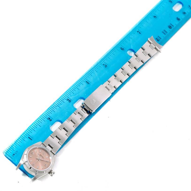 The image shows a Rolex Oyster Perpetual 76030 Women's Stainless Steel Pink Dial 76030 Women's Stainless Steel Pink Dial watch laying flat next to a ruler, displaying the watch face, link bracelet, and clasp.