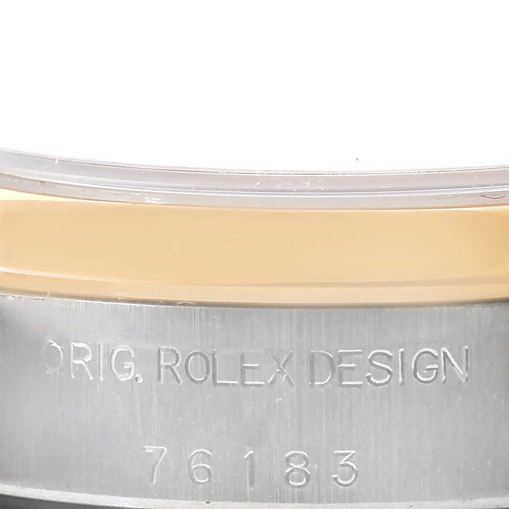 This image shows a close-up of the side of a Rolex Oyster Perpetual 76183 Women's Steel and Gold (two tone) Grey Dial 76183 Women's Steel and Gold (two tone) Grey Dial with the engraved text "ORIG. ROLEX DESIGN 76183".