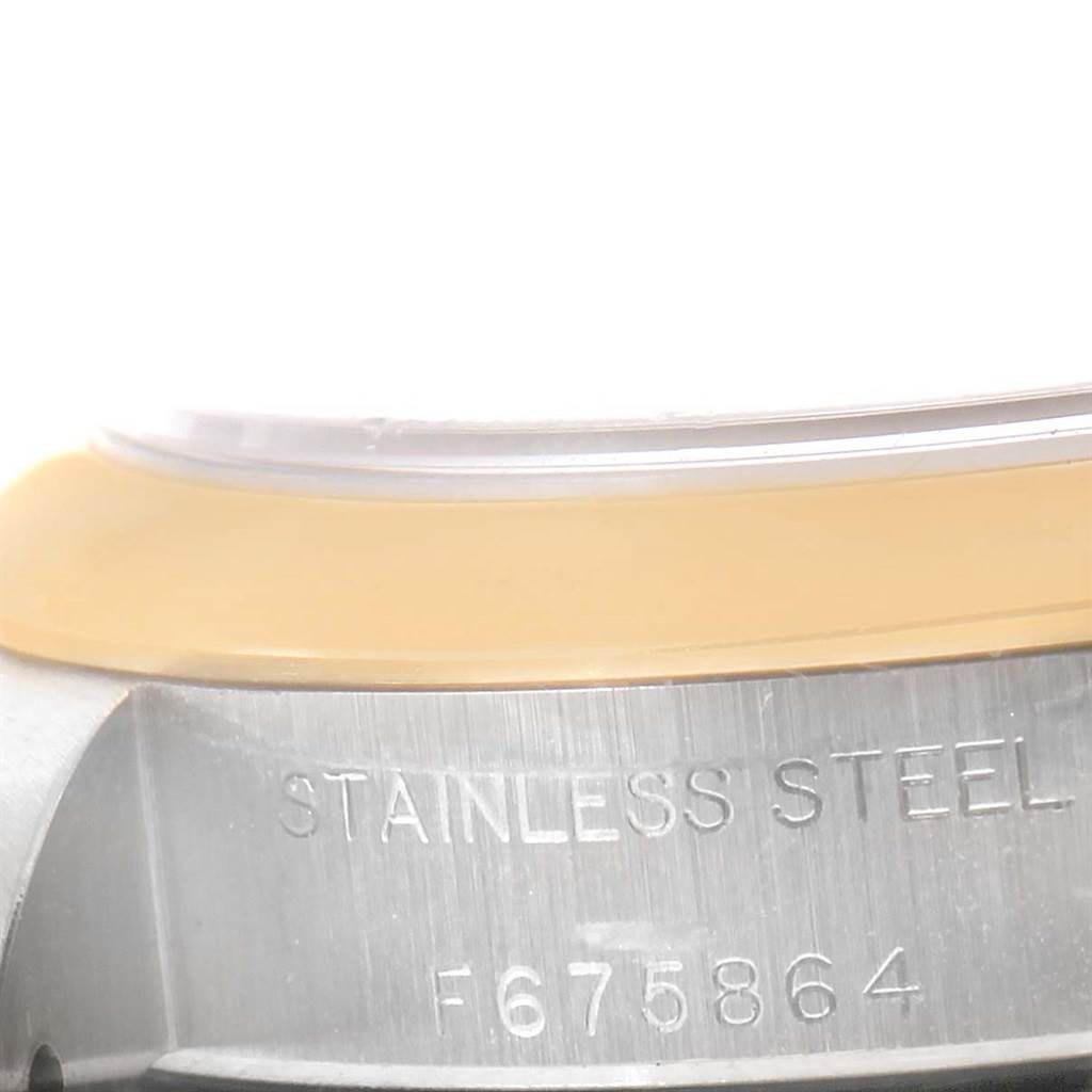 The image shows the side view of the bezel and case of a Rolex Oyster Perpetual 76183 Women's Steel and Gold (two tone) Grey Dial 76183 Women's Steel and Gold (two tone) Grey Dial watch, with the stainless steel inscription and serial number visible.