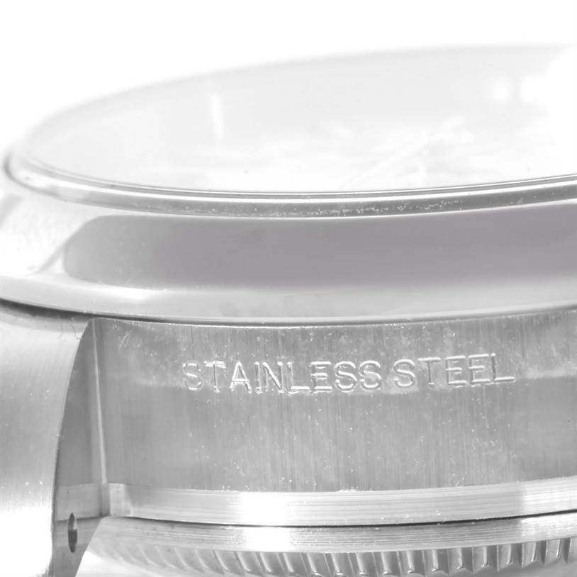 This image shows a close-up angle of the case side and bezel of a Rolex Oyster Perpetual 176200 Women's Stainless Steel White Dial 176200 Women's Stainless Steel White Dial watch, highlighting the "Stainless Steel" engraving.