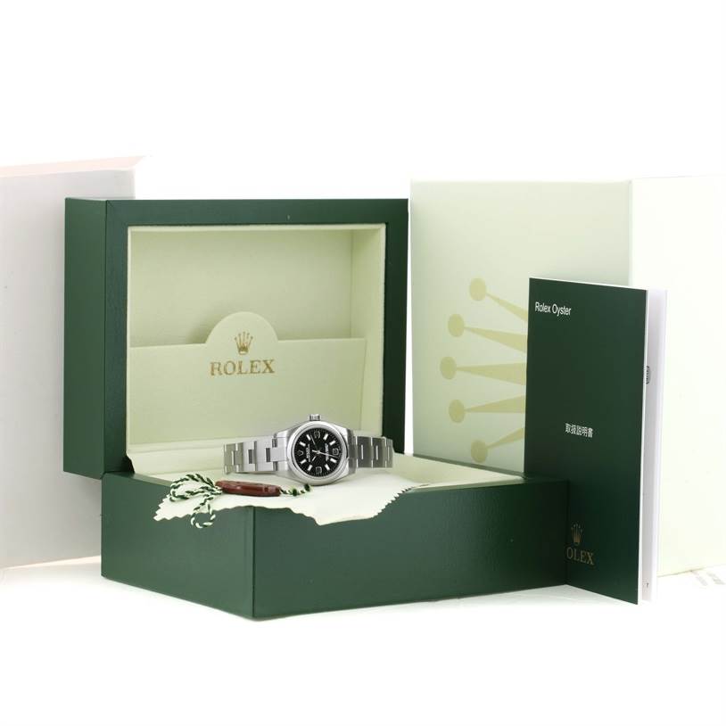 The Rolex Oyster Perpetual 176200 Women's Stainless Steel Black Dial 176200 Women's Stainless Steel Black Dial watch is displayed in its box alongside a booklet, viewed from a front angle.