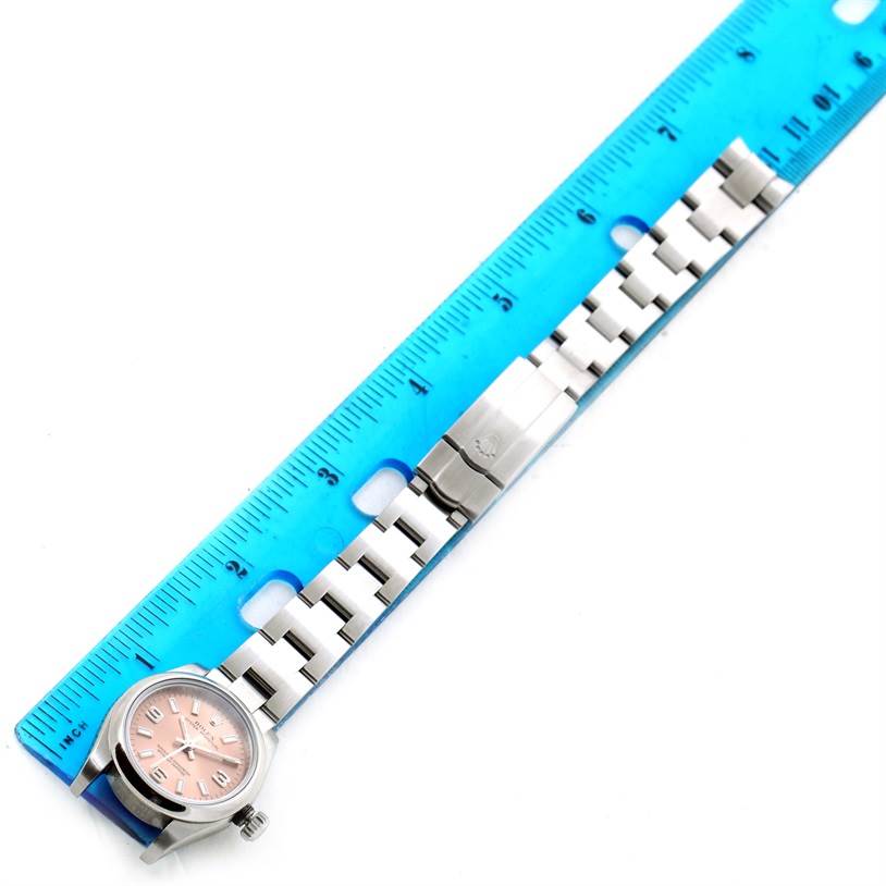 The image shows the face and band of a Rolex Oyster Perpetual 176200 Women's Stainless Steel Pink Dial 176200 Women's Stainless Steel Pink Dial watch laid next to a blue ruler.
