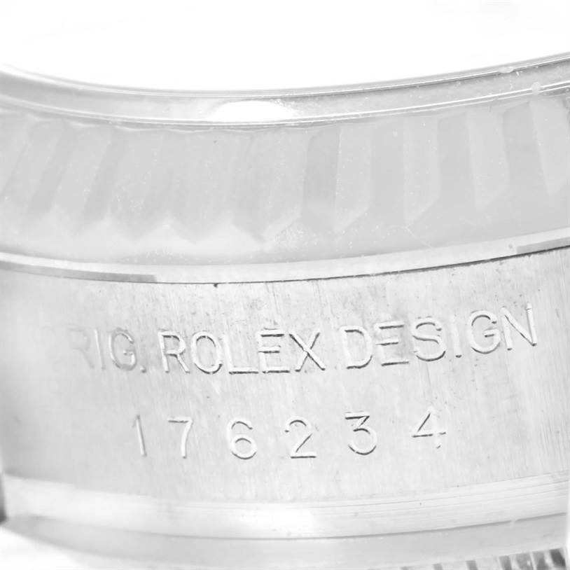 The image shows a close-up of the engraved serial number and "ORIG. ROLEX DESIGN" text on the case of a Rolex Oyster Perpetual 176234 Women
s Stainless Steel Silver Dial 176234 Women
s Stainless Steel Silver Dial watch.