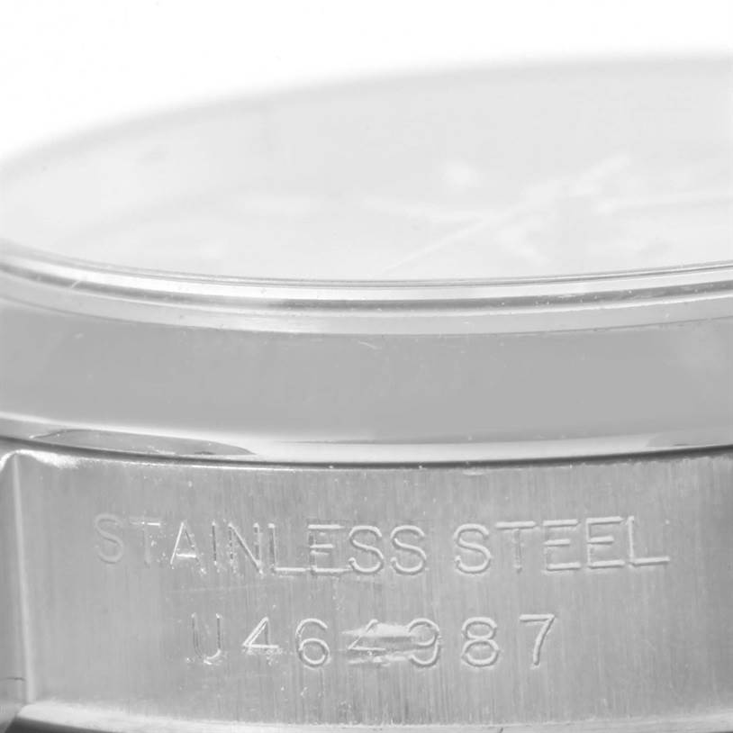 The image shows a close-up of the side of a Rolex Oyster Perpetual 67180 Women's Stainless Steel Pink Dial 67180 Women's Stainless Steel Pink Dial watch, highlighting the "STAINLESS STEEL" engraving and serial number.