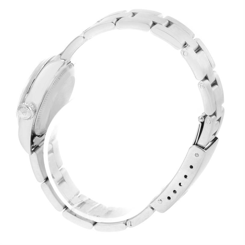 This is a side profile view of a Rolex Oyster Perpetual 67180 Women's Stainless Steel Pink Dial 67180 Women's Stainless Steel Pink Dial watch, showing the case, clasp, and metal bracelet.