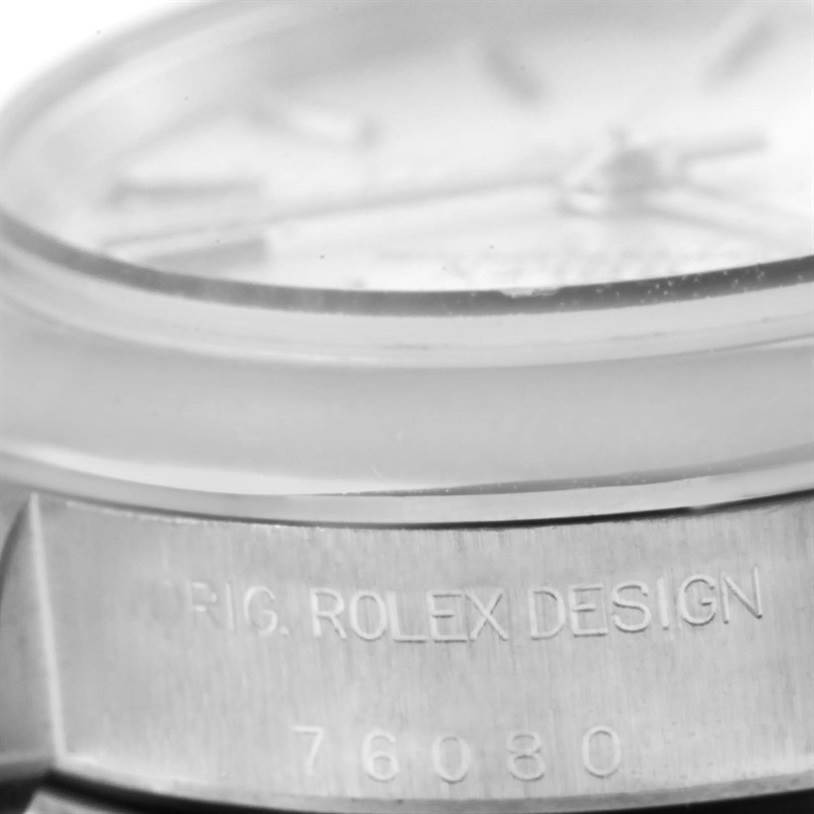 The image shows a close-up of the case and bezel of a Rolex Oyster Perpetual 76080 Women
s Stainless Steel Silver Dial 76080 Women
s Stainless Steel Silver Dial watch.