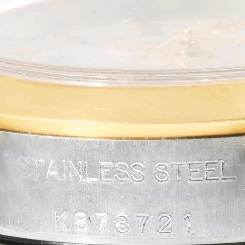 The image shows a close-up of the side of an Oyster Perpetual Rolex watch, focusing on the gold bezel and stainless steel case with serial number.