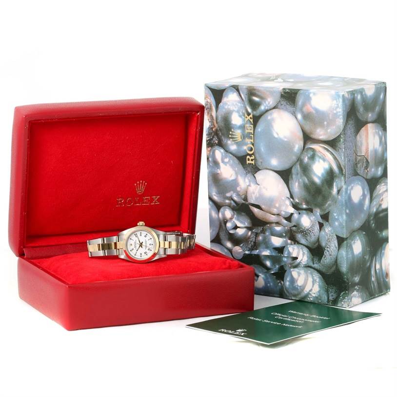 The Rolex Oyster Perpetual 76183 Women's Steel and Gold (two tone) White Dial 76183 Women's Steel and Gold (two tone) White Dial watch is displayed at a straight angle inside an open red box, next to its outer box and accompanying documents.