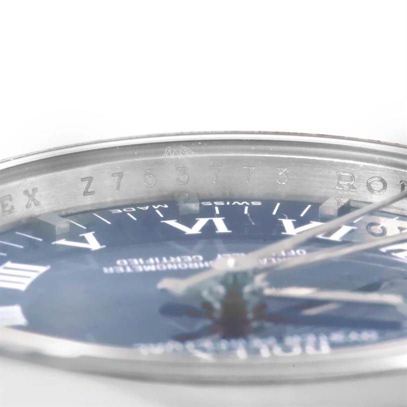 This image shows a close-up angle of the Rolex Oyster Perpetual 176200 Women's Stainless Steel Blue Dial 176200 Women's Stainless Steel Blue Dial watch displaying its bezel, part of the dial, and serial number.