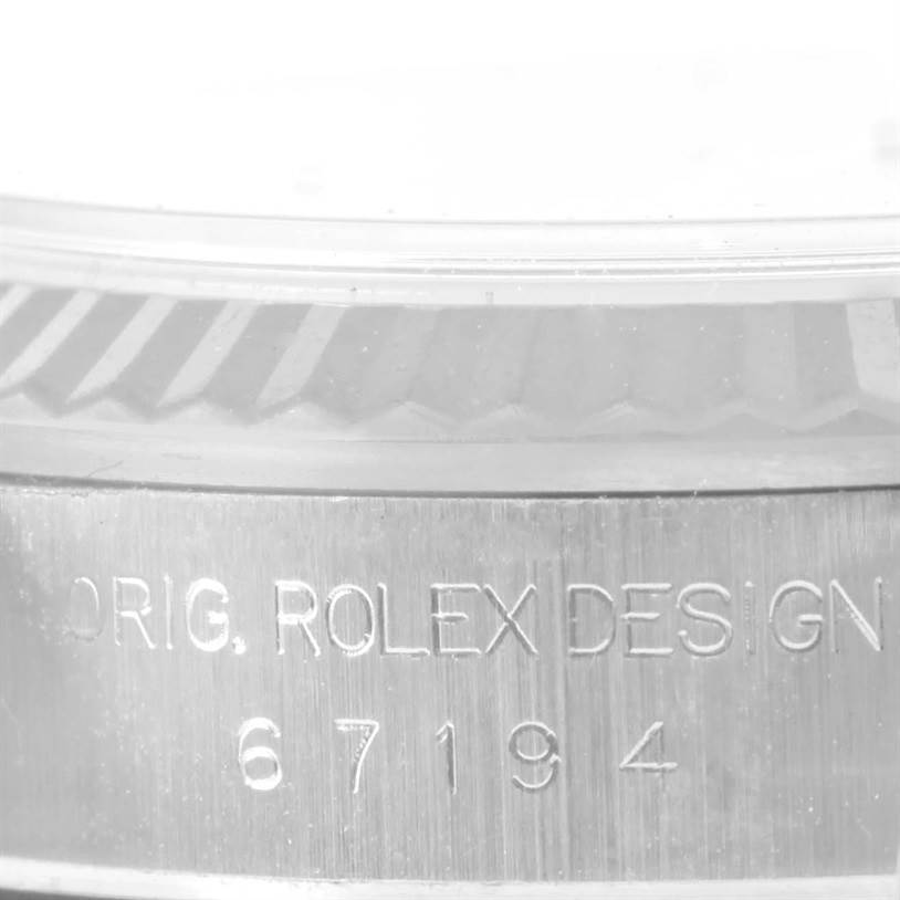The image shows a close-up of the side of an Oyster Perpetual Rolex watch with the engraved model number and design details.