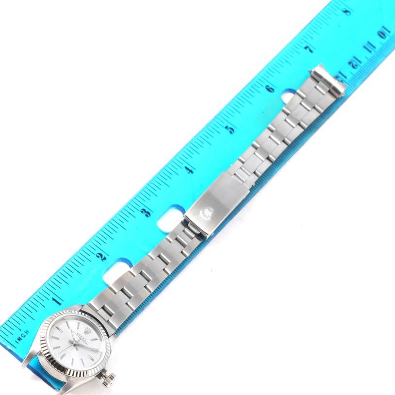 The image shows a Rolex Oyster Perpetual 67194 Women's Stainless Steel Silver Dial 67194 Women's Stainless Steel Silver Dial watch laid flat with its metal band next to a ruler for measurement.