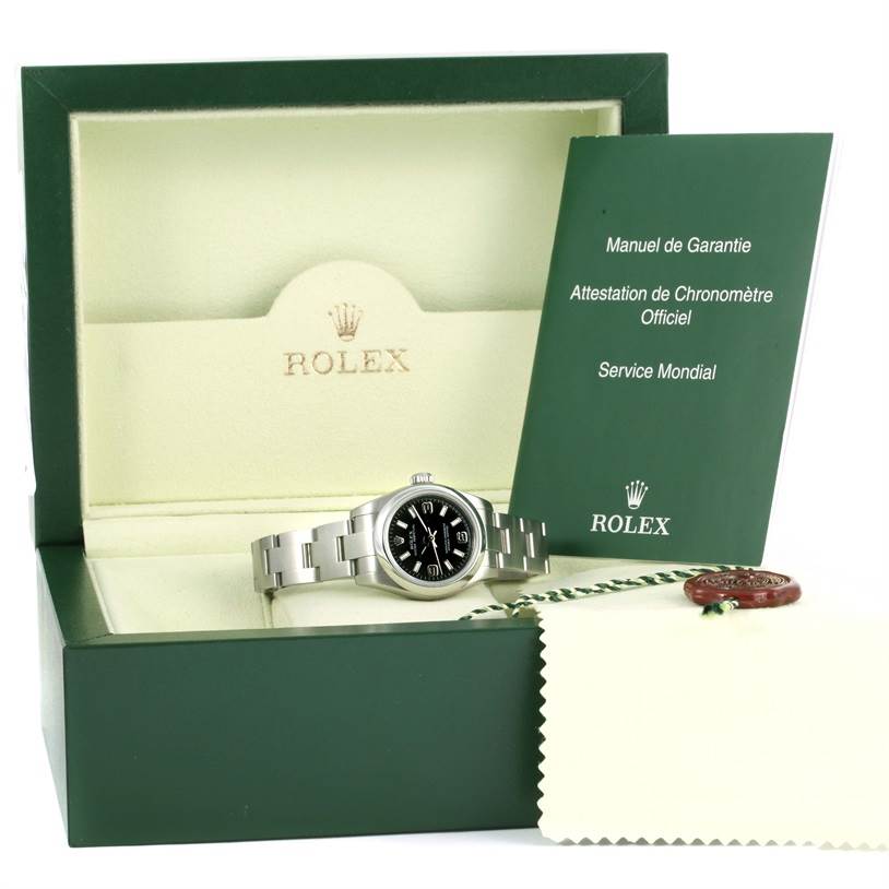 The image shows a Rolex Oyster Perpetual 176200 Women's Stainless Steel Black Dial 176200 Women's Stainless Steel Black Dial watch in an open box with accompanying manuals and a cleaning cloth.